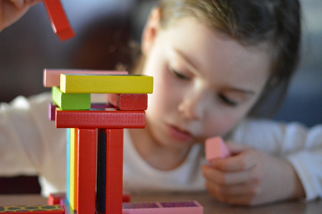 Montessori geometry solids being used by children to learn about 3D shapes and spatial understanding.